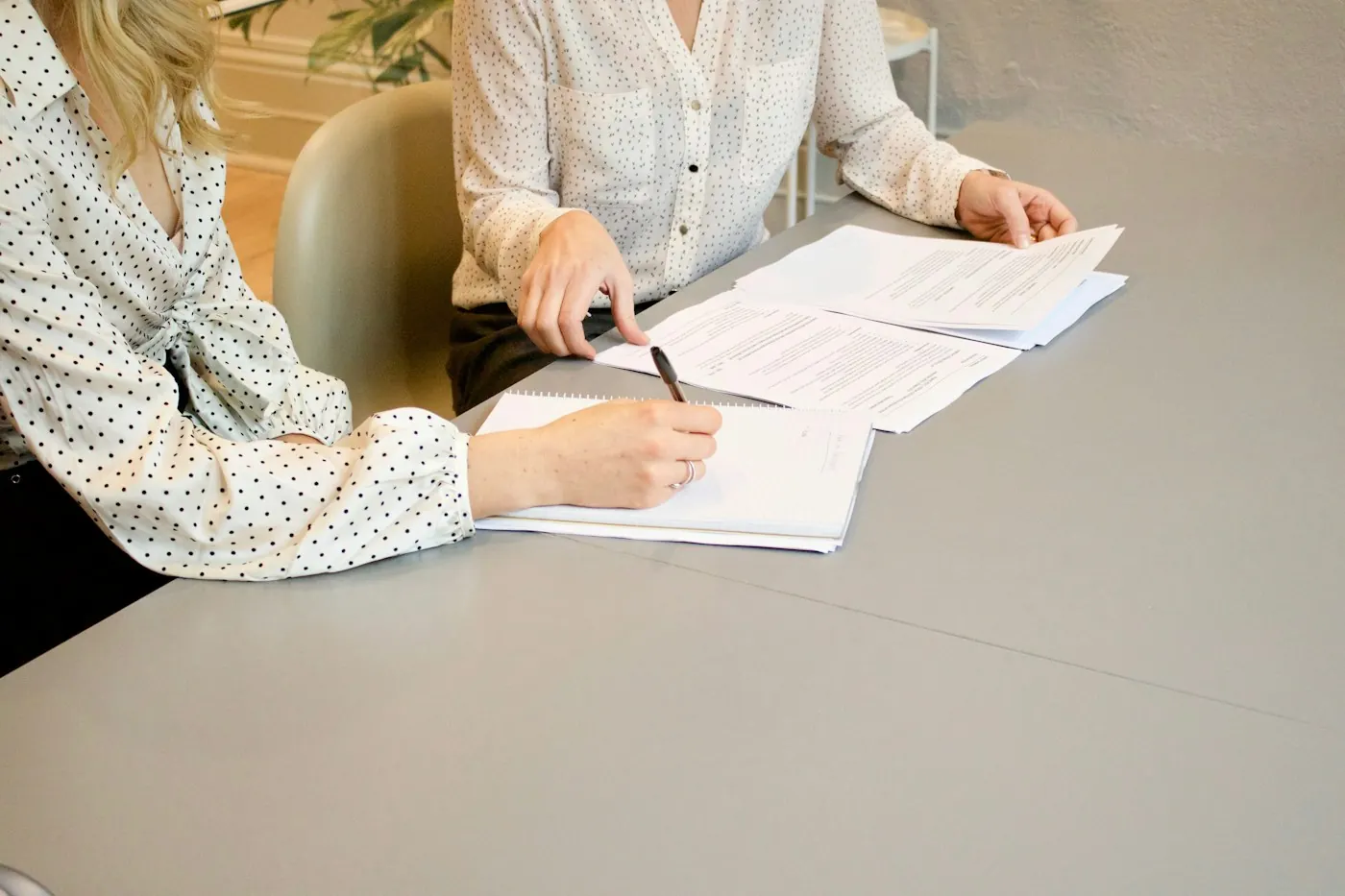 Une personne signe une feuille de présence